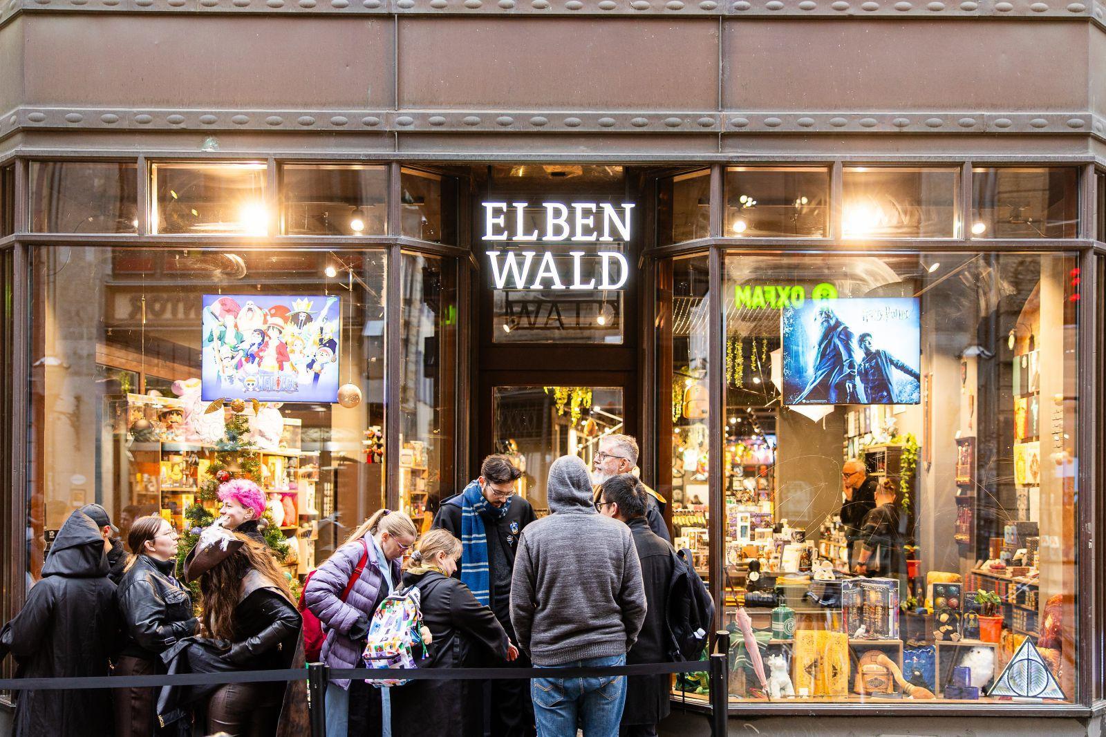 Crowd gathered outside the 'ELBEN WALD' shop with large display windows.